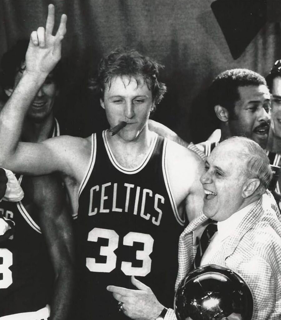 Larry Bird of the Boston Celtics celebrating an NBA Championship title with owner Red Auerbach